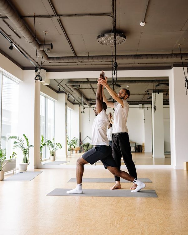Man performing a functional strength exercise in a bright studio.
